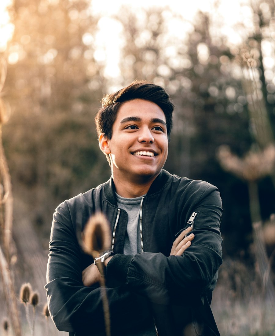 A man smiling outdoors in golden light